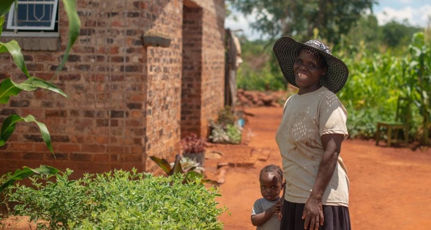 Woman and her young son in front of a house in Zimbabwe