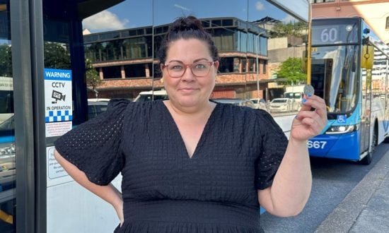 Woman at a bus stop holding up a 50-cent piece