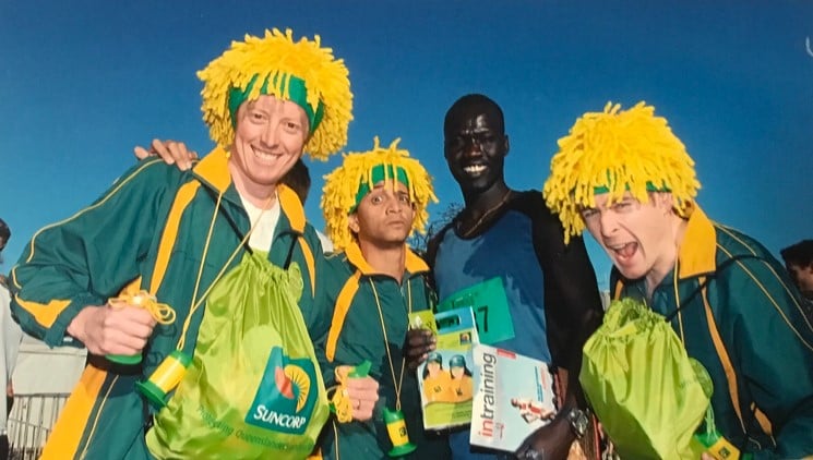 African winning of running race with three men wearing yellow wigs 