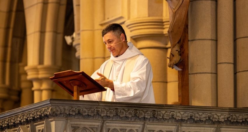 Priest in white robes in a pulpit