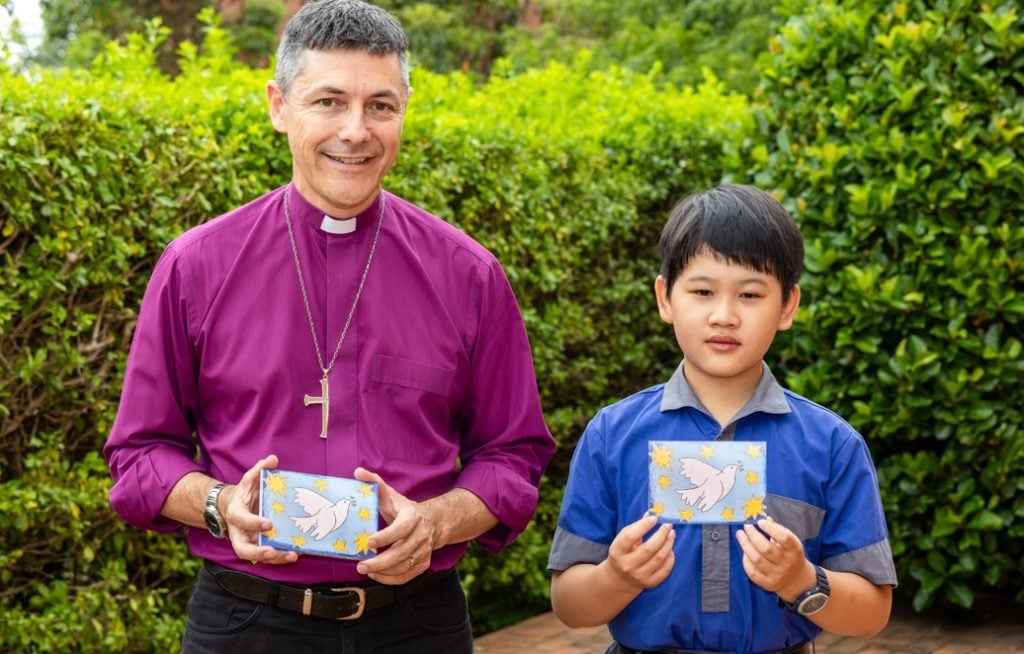 Archbishop in purple shirt with a school boy