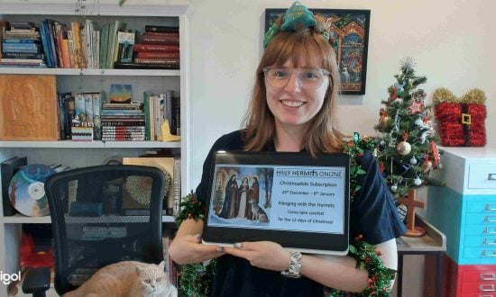 Woman priest holding a tablet with Christmas decorations in the background