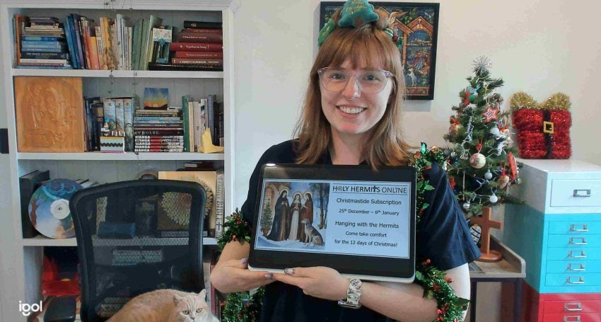 Woman priest holding a tablet with Christmas decorations in the background