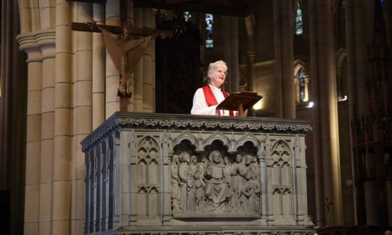 Woman bishop giving a sermon from a cathedral pulpit