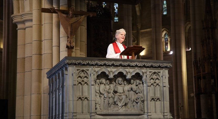 Woman bishop giving a sermon from a cathedral pulpit