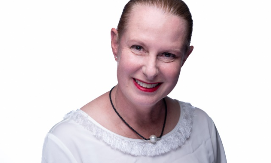 Woman in white blouse smiling at the camera