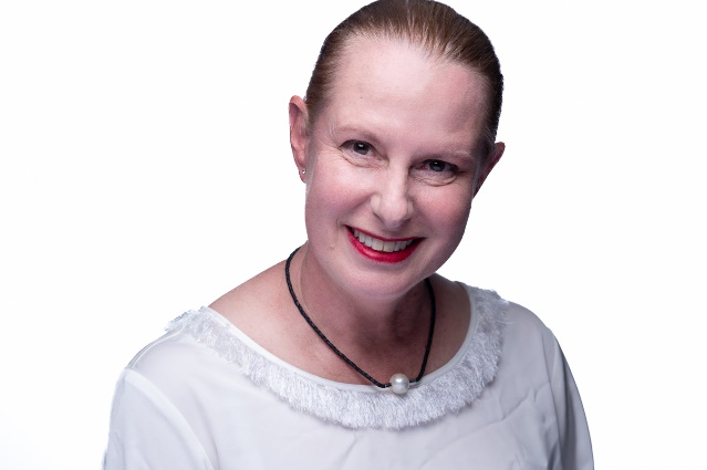 Woman in white blouse smiling at the camera