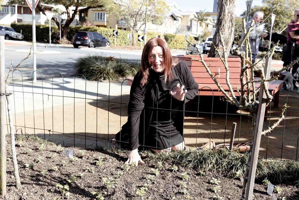 Woman priest in front of a garden 