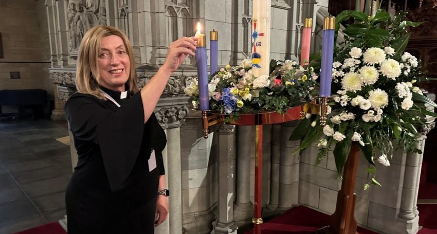 Priest lighting Advent candles in a Cathedral