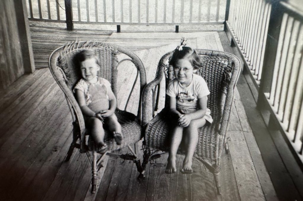 Two young sisters sitting on a patio in the 1960s in regional Queensland 