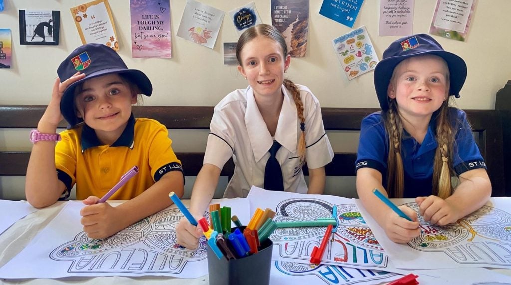 Three students coloring in at school 