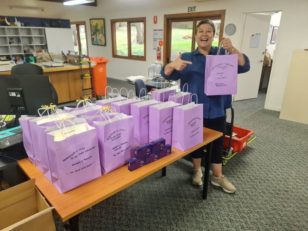 Woman holding purple bags in a lecture room