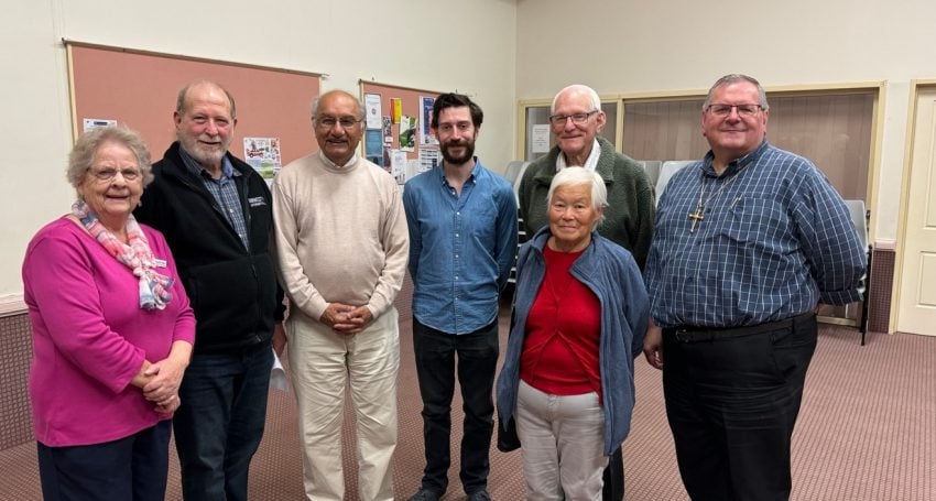 Group of people in a church hall smiling at the camera