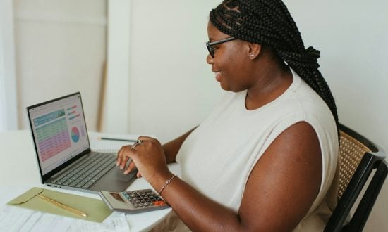 African woman working on her PC looking at a graph, table and chart