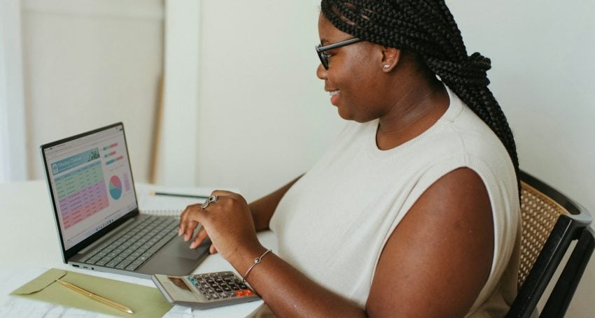 African woman working on her PC looking at a graph, table and chart