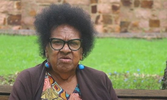 Torres Strait Islander woman elder sitting outside
