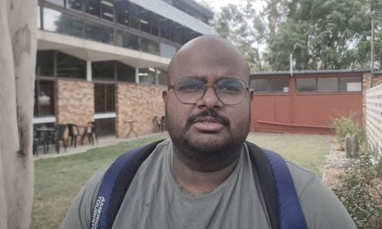 A man poses for a photograph outside