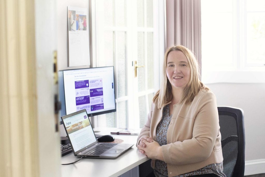 A woman at her office desk looking at the camera