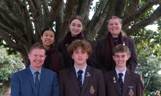 A group of Toowoomba Anglican School students and staff involved with the school's newly created Amnesty International Group, standing in front of a large tree
