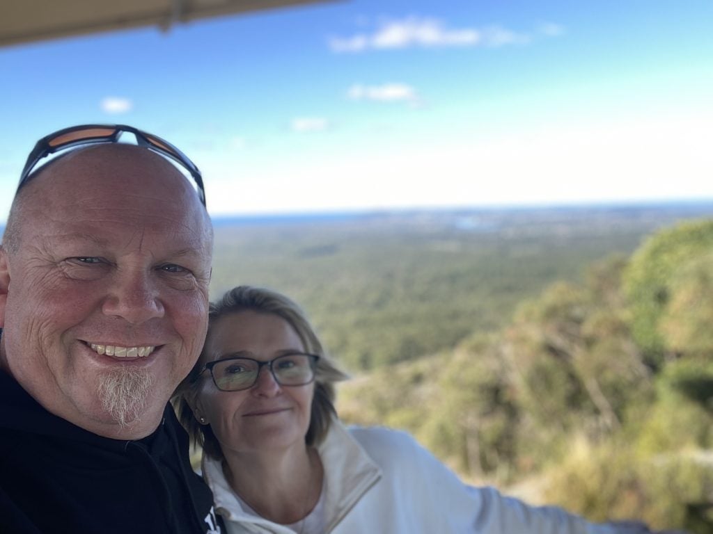 Two people posing for a photograph against the backdrop of Noosa