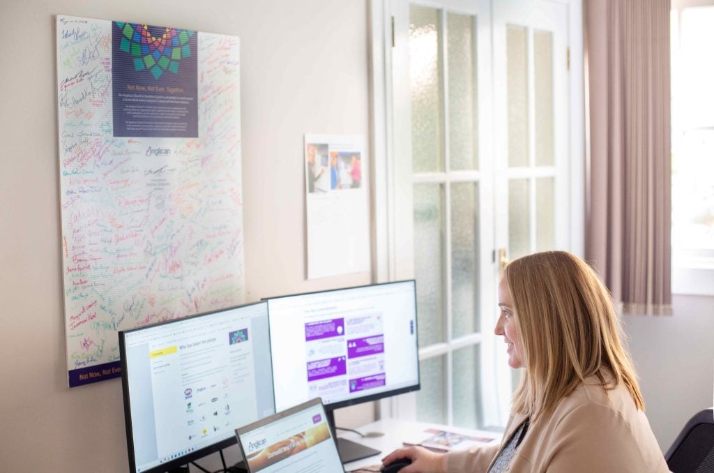 A woman working at a desk in front of her PC