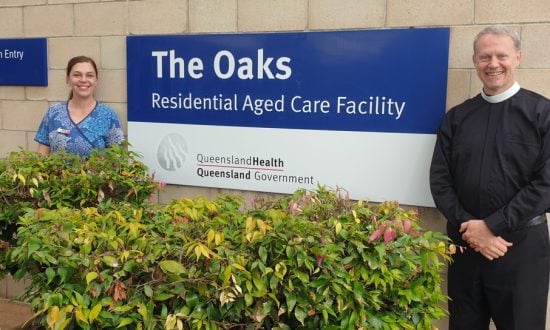 Priest and aged care worker outside an aged facility centre