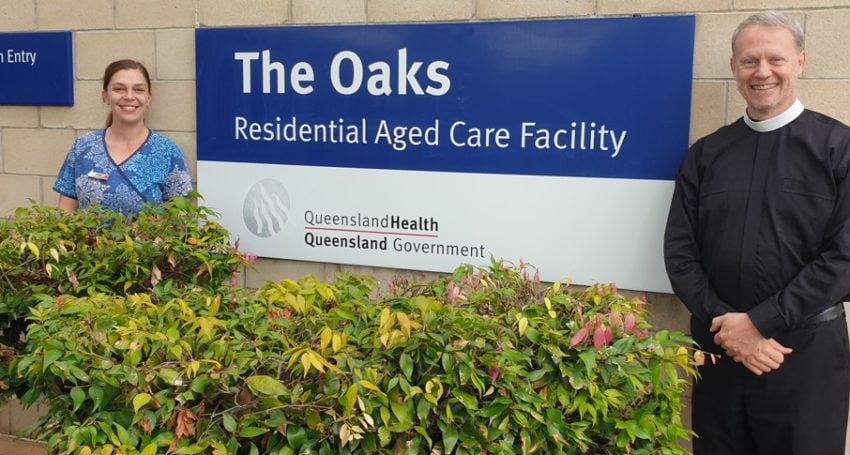 Priest and aged care worker outside an aged facility centre