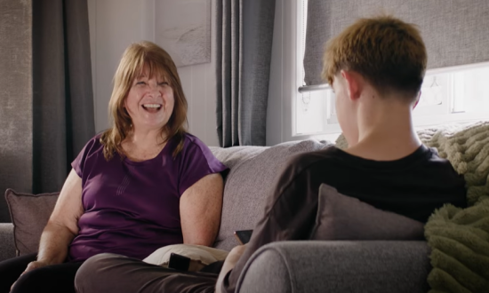 A female youth worker is sitting on a couch opposite a male youth