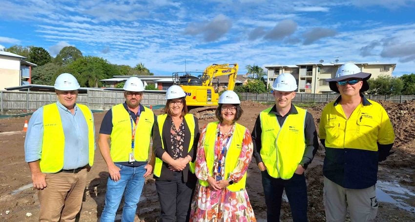 A group of Woollam and Anglicare Southern Queensland staff standing at a construction site.
