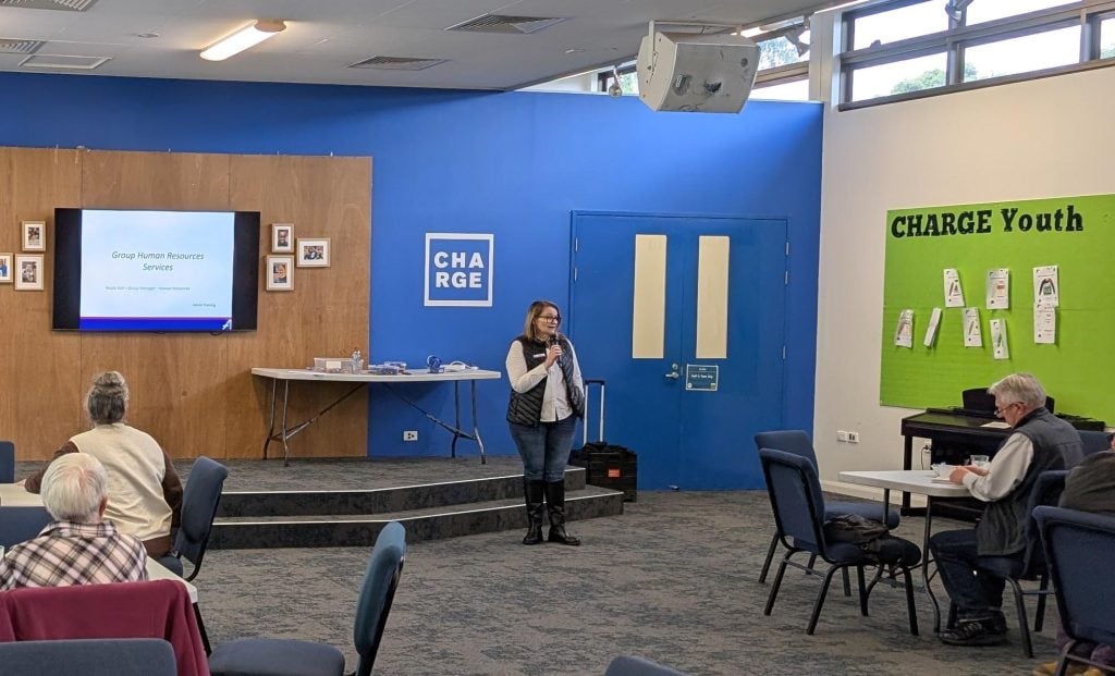A woman in a conference room addressing an audience
