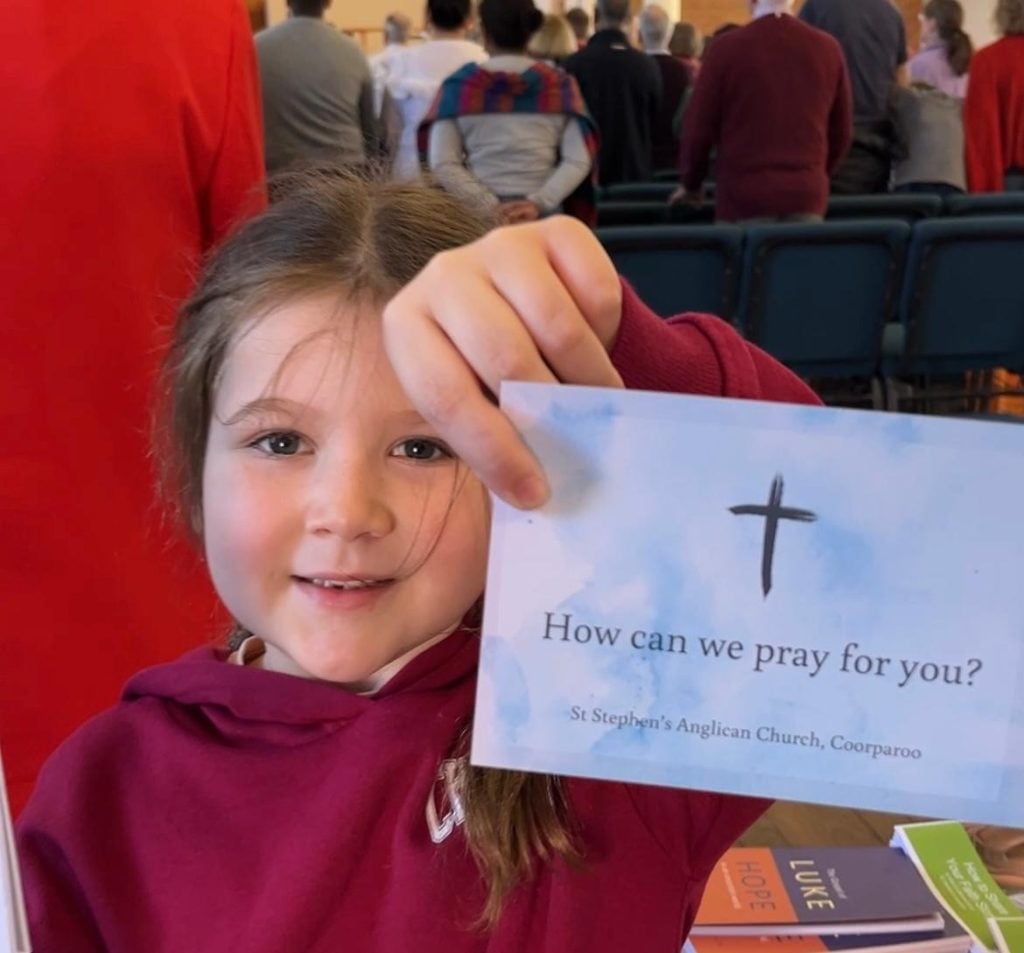 A girl holding a prayer card