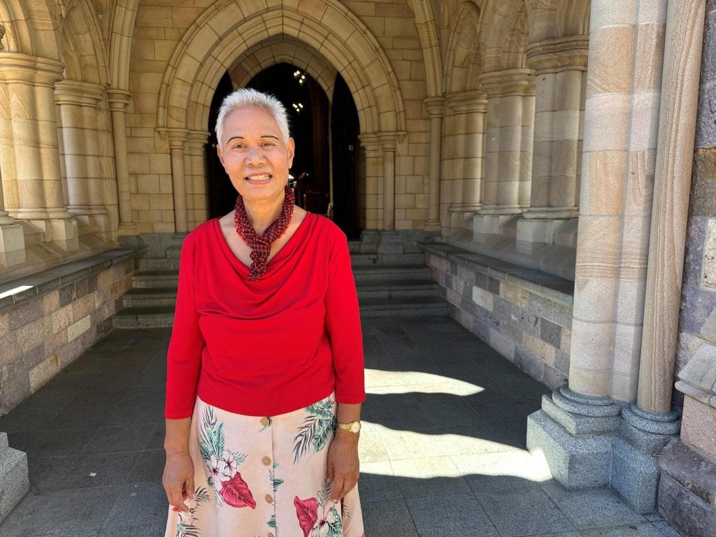 A woman poses for a photograph in front of a cathedral entrance