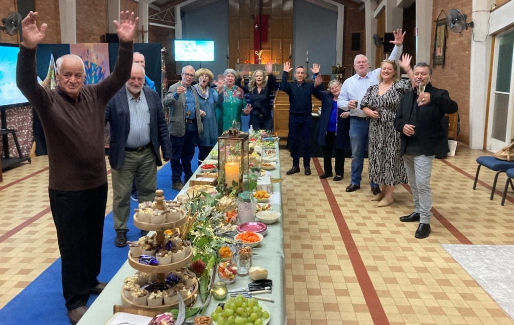 People in a church hall enjoying a wine and cheese night