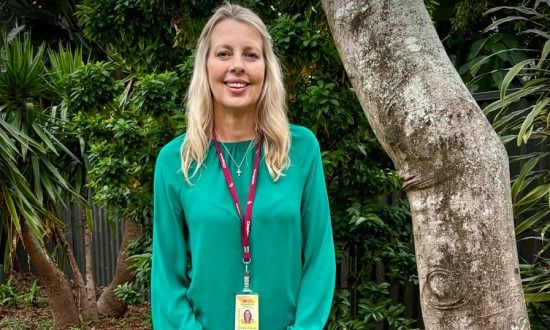 Woman in green long-sleeved top with lanyard around her neck