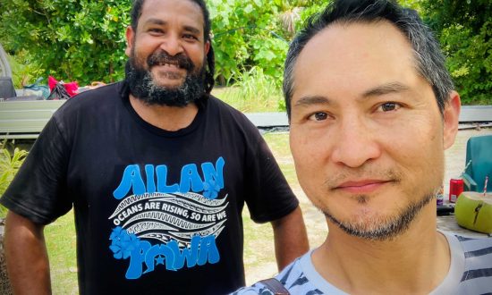 Two men pose for a selfie photograph outside