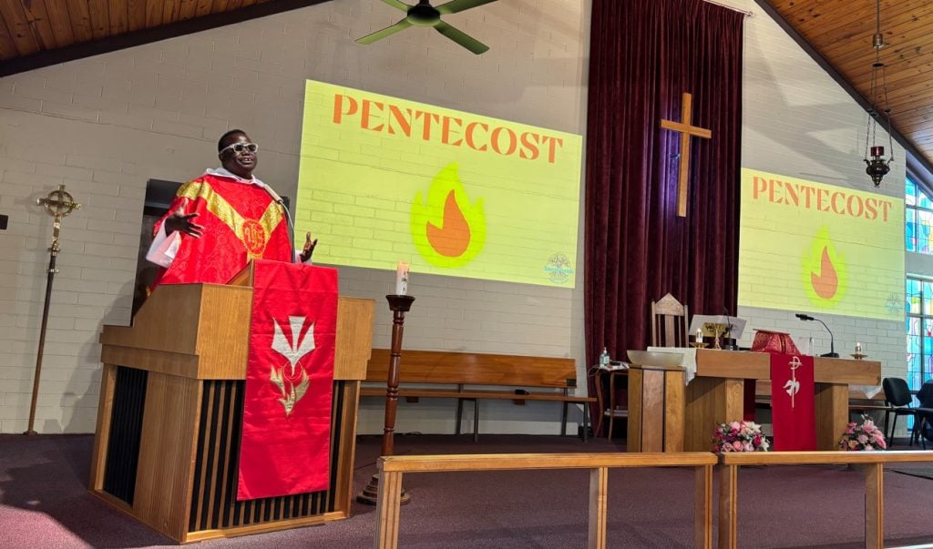 Priest giving a sermon at a church on Pentecost Sunday