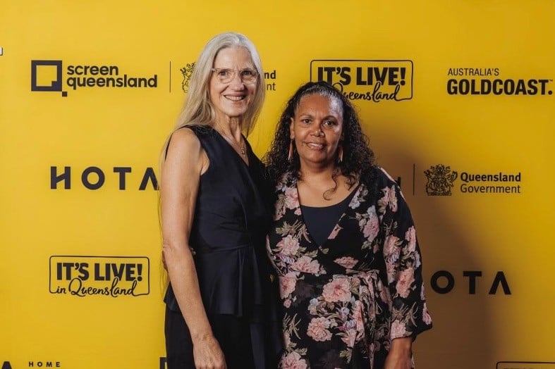 Two women pose for a photograph at an event