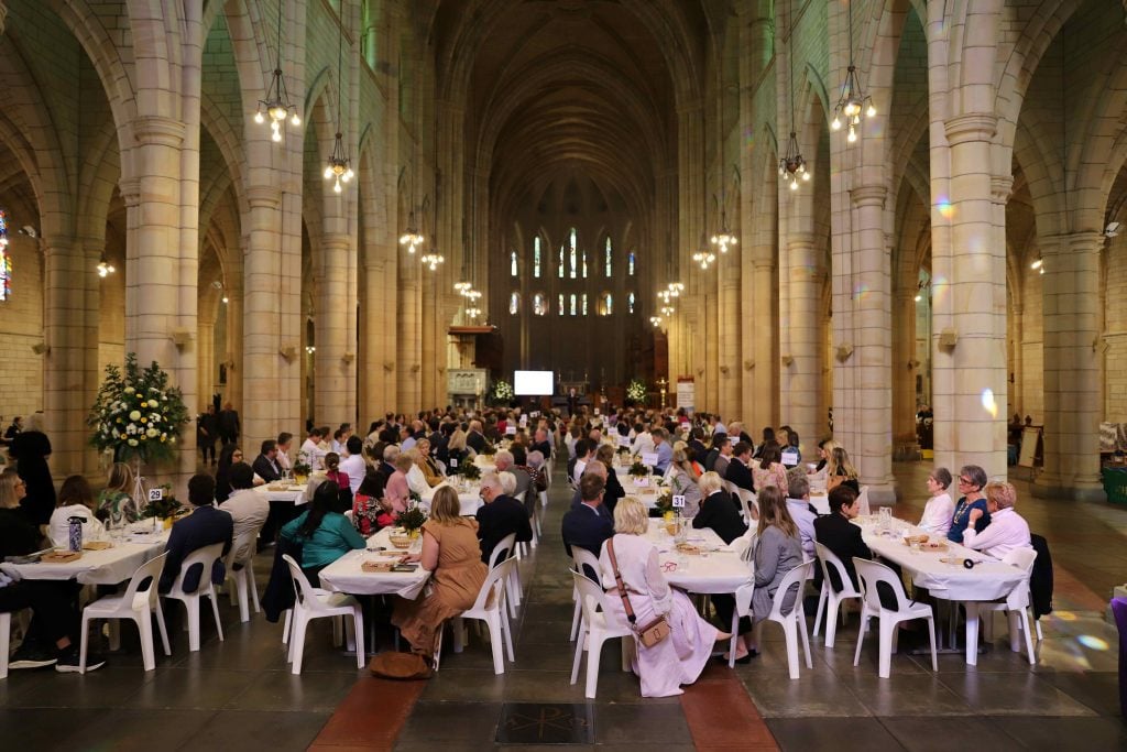 Attendees are seated at tables in St John's Cathedral