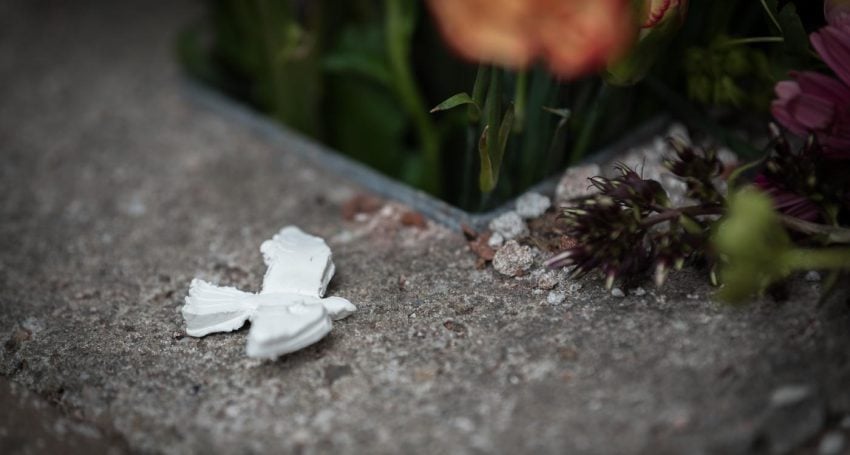 A dove trinket resting on concrete