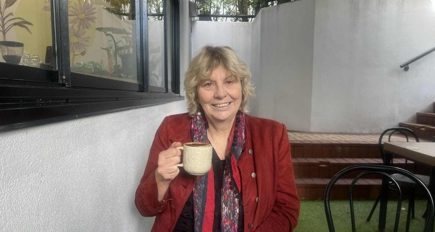 Woman in red jacket drinking a coffee