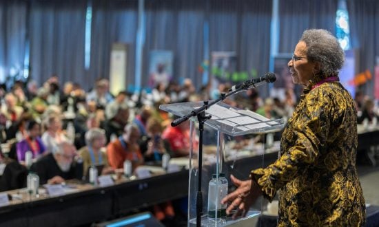 A woman addresses an audience from a stage at an international conference