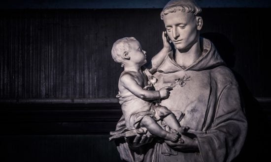 Statue of a saint wearing a robe holding a baby