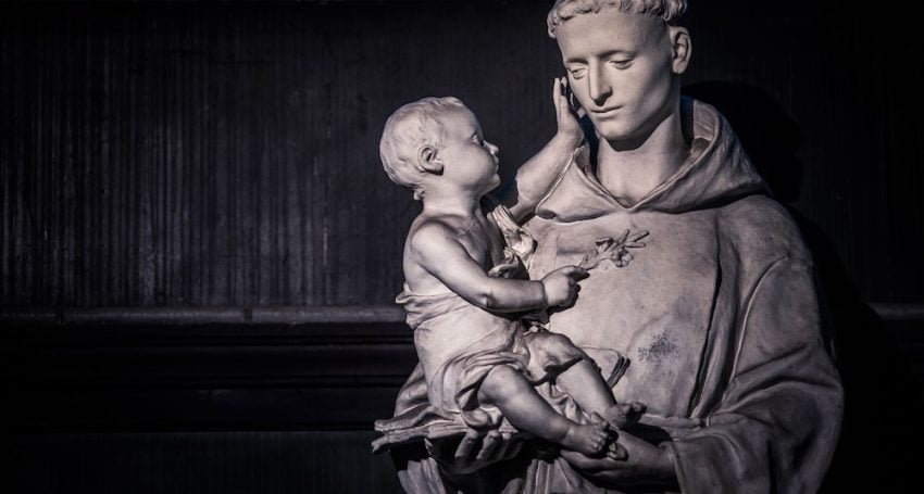 Statue of a saint wearing a robe holding a baby