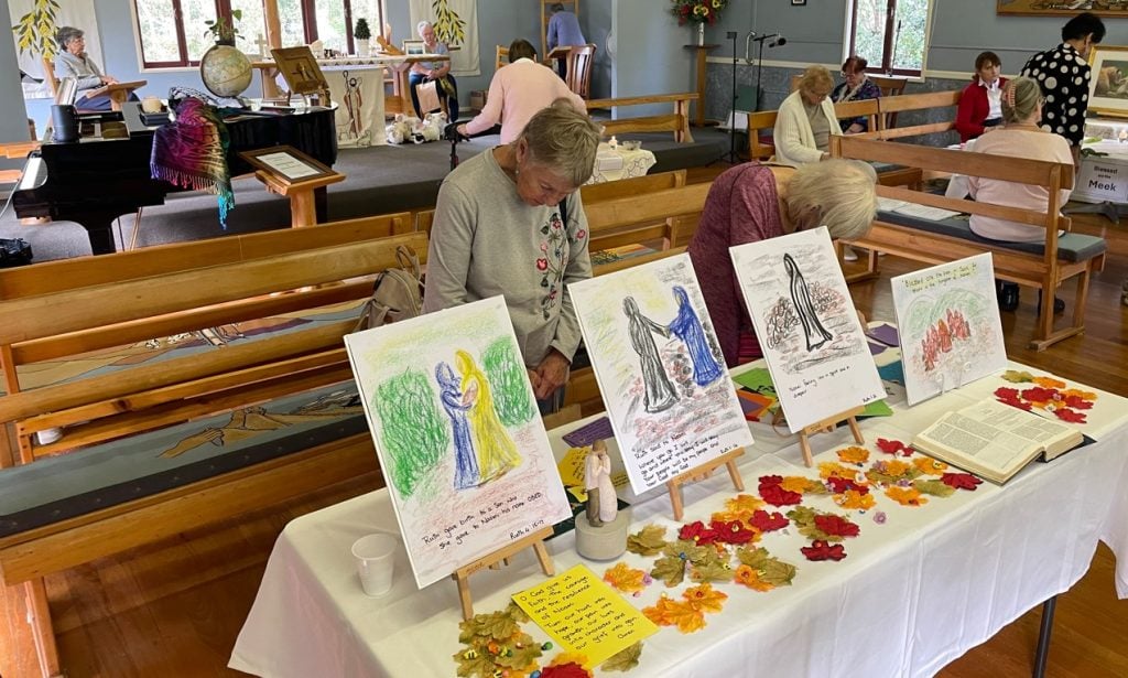 Women at prayer stations in a church hall
