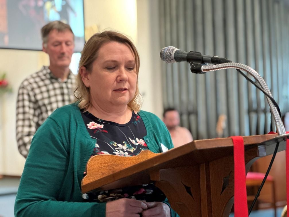 Woman speaking at a lectern during a church service 