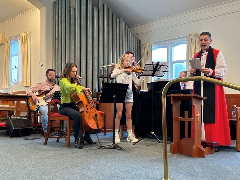 Musicians and an Archbishop in the sanctuary area of a church 