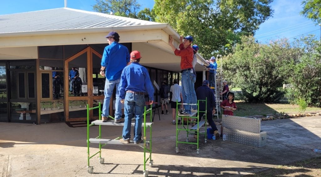 Students and teachers painting church eaves and fascia