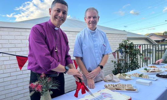 Archbishop and priest cutting a cake