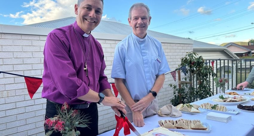 Archbishop and priest cutting a cake