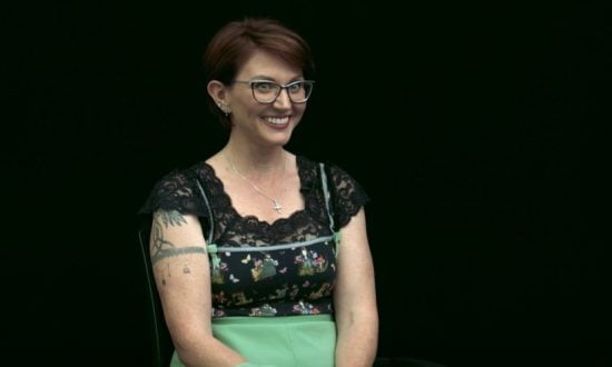 A woman being interviewed against a black background